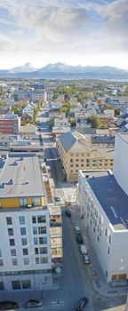 Above view of urban city streets in popular overseas travel destination in Bodo, Norway. Busy downtown centre and urban infrastructure of building architecture with scenic mountains in the background