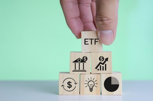 wooden cube block icon ETF Exchange Traded Fund on table.Business stock market finance Index Fund Concept. 