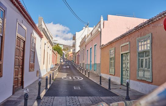 Historical city street view of residential houses in small and narrow alley or road in tropical Santa Cruz, La Palma, Spain. Village view of vibrant buildings in popular tourism destination overseas