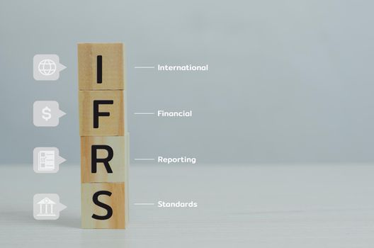 wooden cubes IFRS International Financial Reporting Standards with on table and copy space.Business financial concepts.