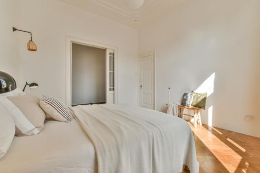 Wide bed in light spacious bedroom