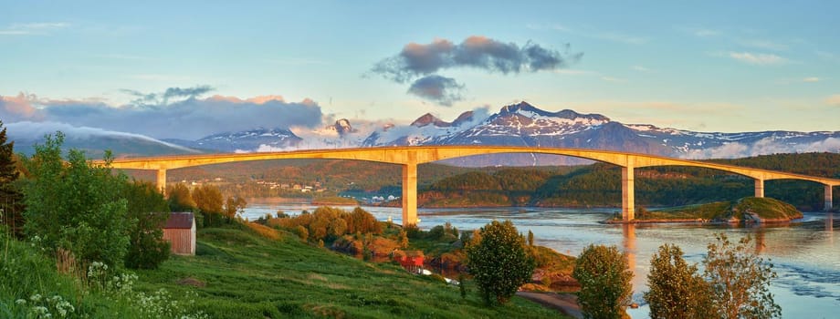 Landscape view of Saltstraumen Bridge in Nordland, Norway in winter. Scenery of transport infrastructure over a river or stream with a snow capped mountain background in travels abroad and overseas