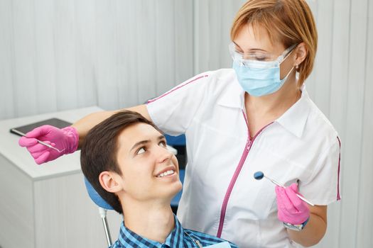 Female dentist and young man in dentist office