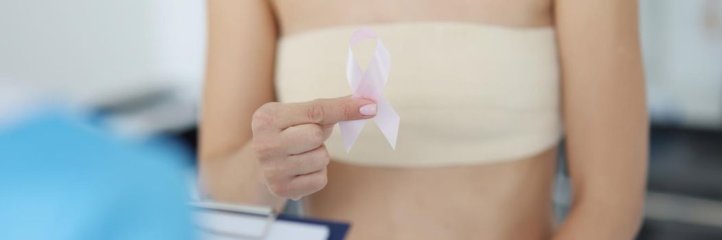 Female client hold white ribbon sign of breast cancer