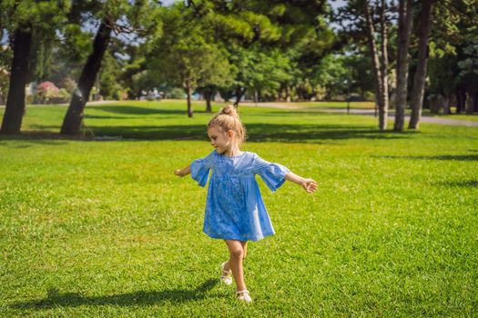 Cute little girl on green grass in park