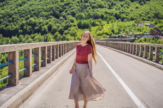 Montenegro. Woman tourist in background of Dzhurdzhevich Bridge Over The River Tara. Travel around Montenegro concept. Sights of Montenegro