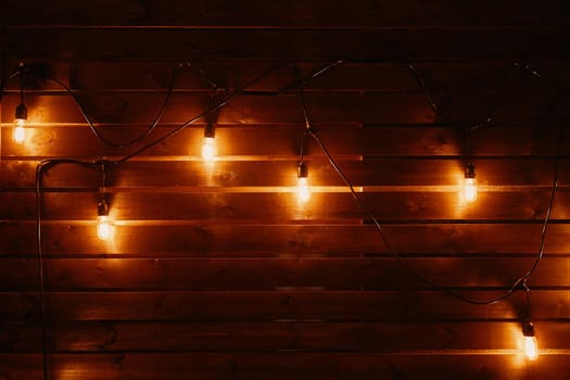 Hanging light bulbs over the wooden background.