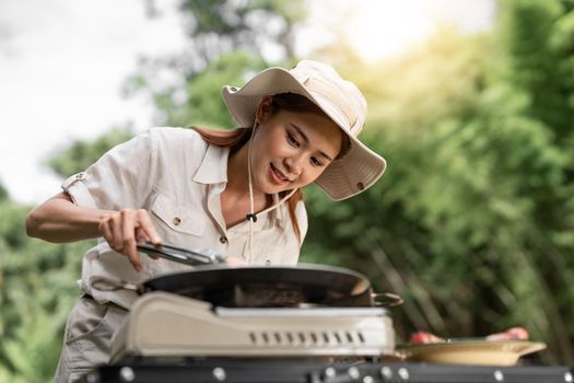 Young aisan girl grilling barbecue in the campground at summer camp travel, Skewers of pork and beef fillet on barbecue party in camping, Summer Camp Travel one activity for relaxing..