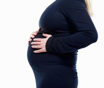 Pregnant woman feeling her baby against white - copyspace. Mid section of a pregnant woman feeling her baby against white - copyspace.