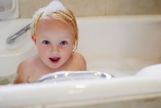 Bubble bath fun. Portrait of an adorable little girl having a bubble bath.