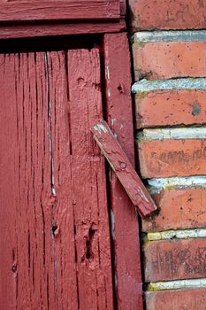 Doors. Closeup of an old red wooden door in a face brick building,most likely a house in a residential district. A latch lock on an entrance way.