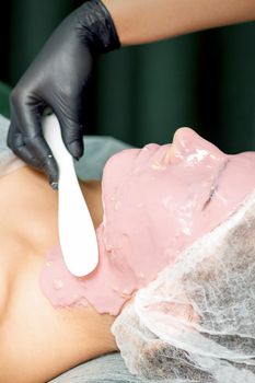 Cosmetologist applying an alginic mask