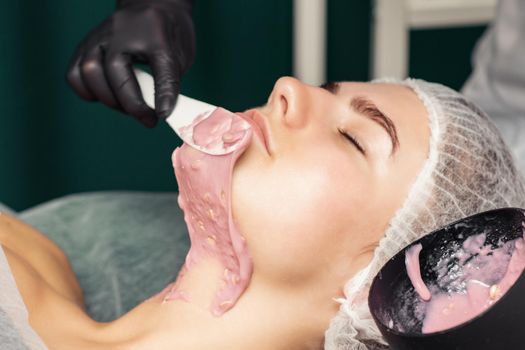 Cosmetologist applying an alginic mask