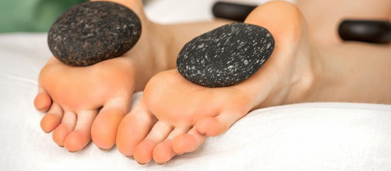 Massage stones on soles feet