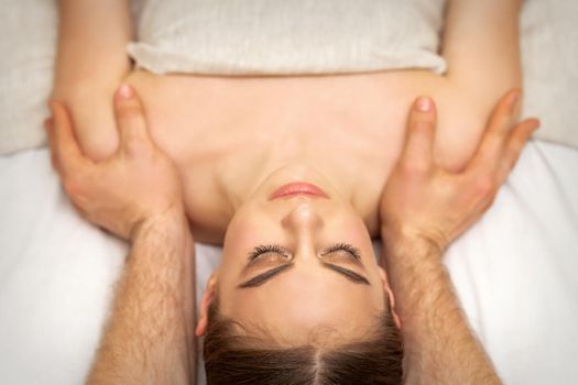 Masseur doing shoulder massage in spa