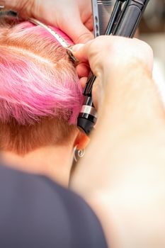 Hairdresser pinches hair with clip