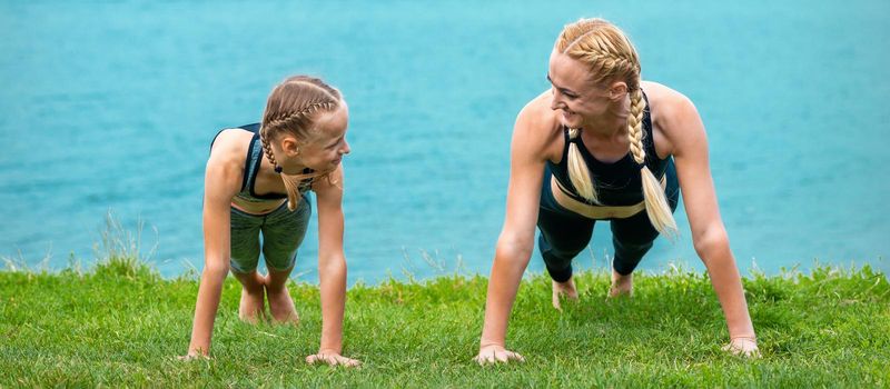 Woman and girl doing push-up exercise