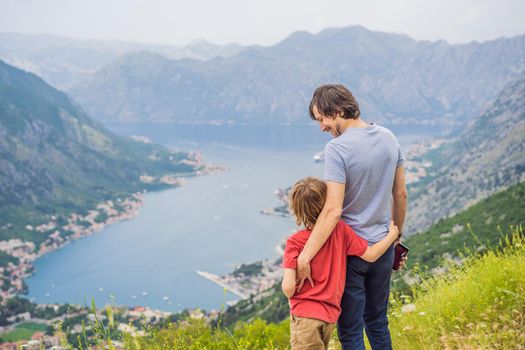 Father and son travellers enjoys the view of Kotor. Montenegro. Bay of Kotor, Gulf of Kotor, Boka Kotorska and walled old city. Travel to Montenegro concept. Fortifications of Kotor is on UNESCO World Heritage