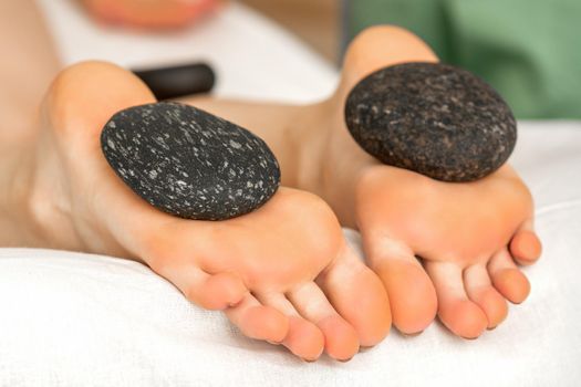 Massage stones on soles feet