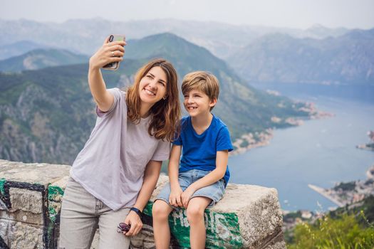 Mother and son travellers enjoys the view of Kotor. Montenegro. Bay of Kotor, Gulf of Kotor, Boka Kotorska and walled old city. Travel to Montenegro concept. Fortifications of Kotor is on UNESCO World Heritage