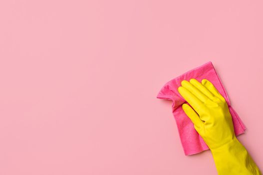Hand in glove on pink background. Cleaning concept