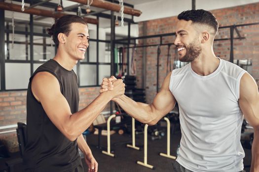 Cheerful athletes greeting each other. Fit bodybuilders collaborate on training together. Strong athletes saying hello in the gym. Confident workout partners make a deal in the gym