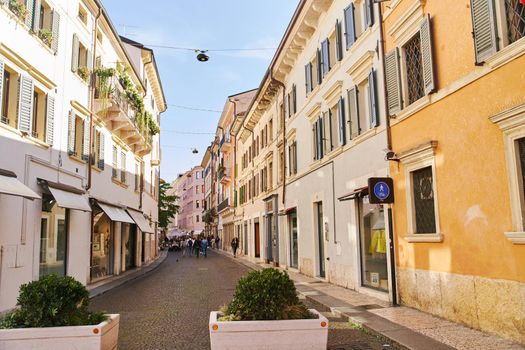 Verona, Italy - October 12, 2021: Narrow sunny cobblestone street in Verona