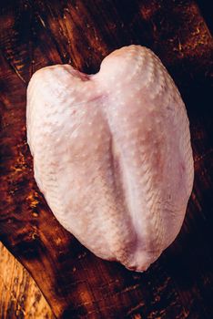 Raw chicken breast on chopping board