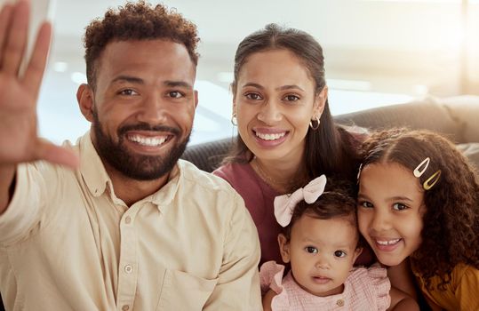 Portrait of smiling mixed race parents taking selfie with adorable daughters. Happy hispanic family taking picture for social media at home. Mother, father and little girls bonding while taking photo