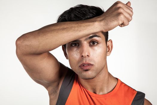 Man standing with hand on forehead, looking at camera, being tired after workout, looking at camera