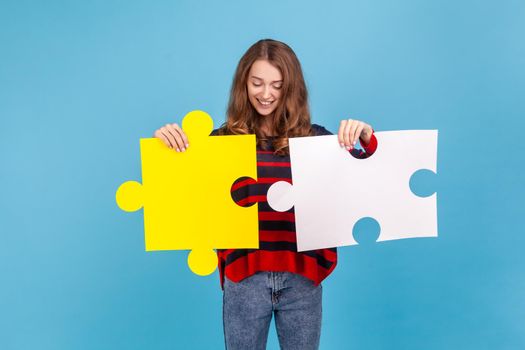 Woman joining two jigsaw pieces, metaphor of unity connection, complete solution.