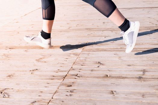 female runner's legs jogging in sneakers