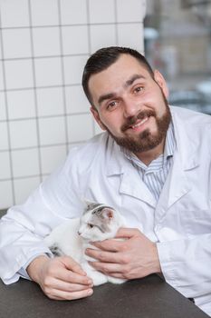 Male vet with a cat at his clinic