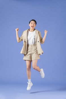 Full length body size photo of girlish cheerful woman jumping stepping smiling isolated purple background