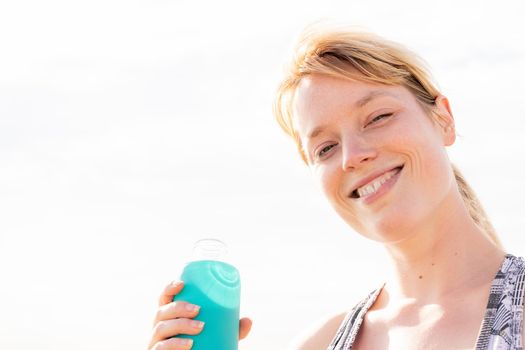 sports woman smiling with a bottle of water