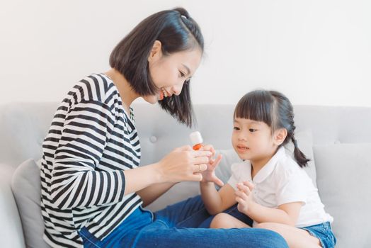 Mom paints nails to daughter