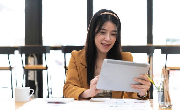 Asian attractive businesswomen using Digital Tablet standing in the office