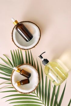 Cracked coconut and a bottle of oil on the table - spa, skincare, haircare and relaxation concept 