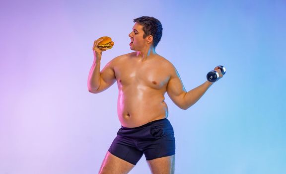 fat man chooses between burger and fitness with dumbbells. Not sporty men eating hamburger isolated on pink background.