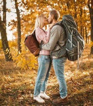 Loving Couple Of Travelers Kisses In Autumn Forest