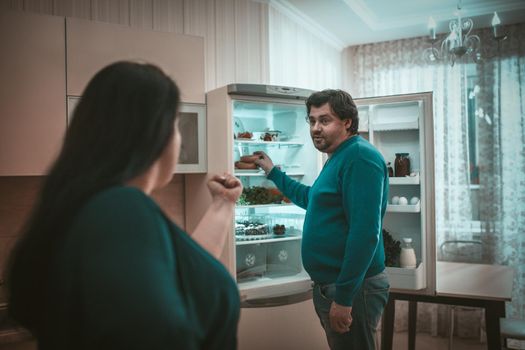 Conflict of Plus Size couple near opened refrigerator