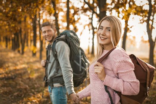 Happy Travelers Walking An Autumn Forest Path Outdoors