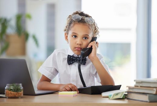 Ive been on hold for hours. an adorable little girl dressed as a businessperson sitting in an office and using a telephone.