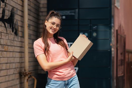 Woman preparing parcel for shipment to client near post office