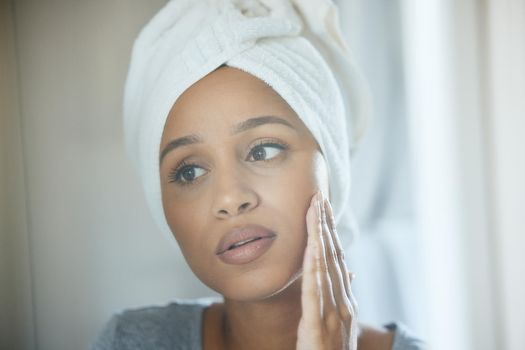 Embrace your natural beauty. a young woman getting ready in a bathroom at home.