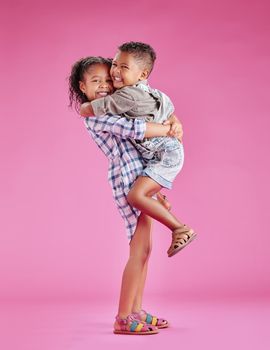 Two children only posing and being affectionate against a pink copyspace background. African American mixed race siblings bonding in a studio