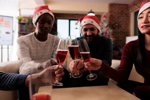 People clinking glasses of wine at xmas office party