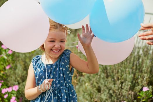 Balloons are great at any occasion. a happy little girl playing with balloons at home.