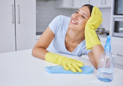 Dreaming of a futuristic self-cleaning home. a young woman smiling while cleaning a kitchen counter.