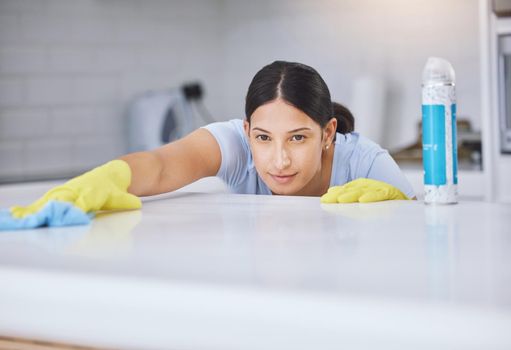 Thats perfect. a young woman smiling while cleaning a kitchen counter.
